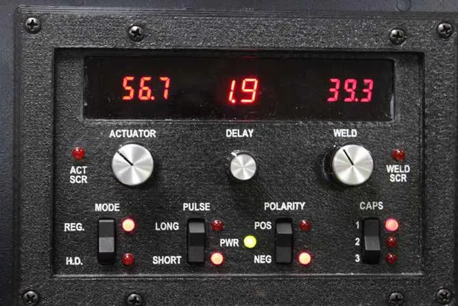 Front panel of the percussion welder with red digital readouts and actuator, delay and weld dials