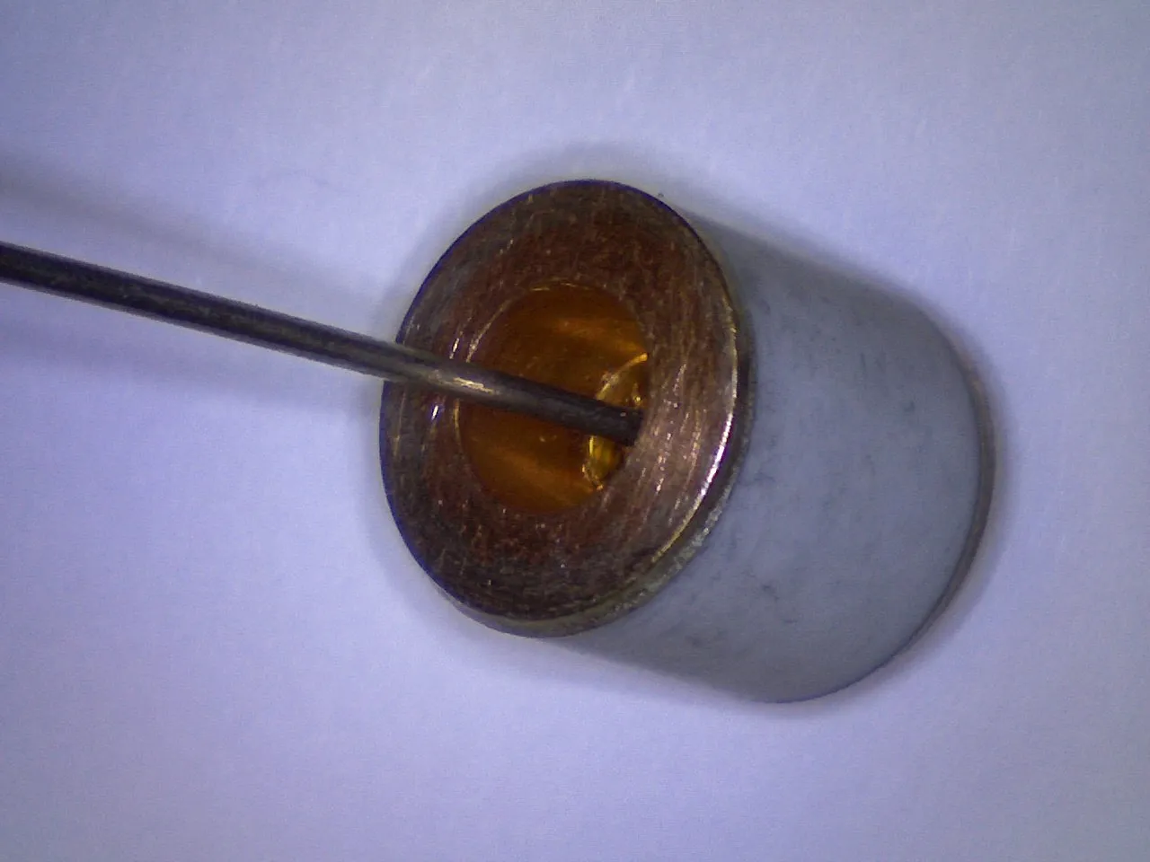 Magnified view of a ceramic tube end with a probe tip inside