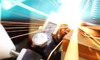 Bright flash and sparks at the weld point between copper electrodes