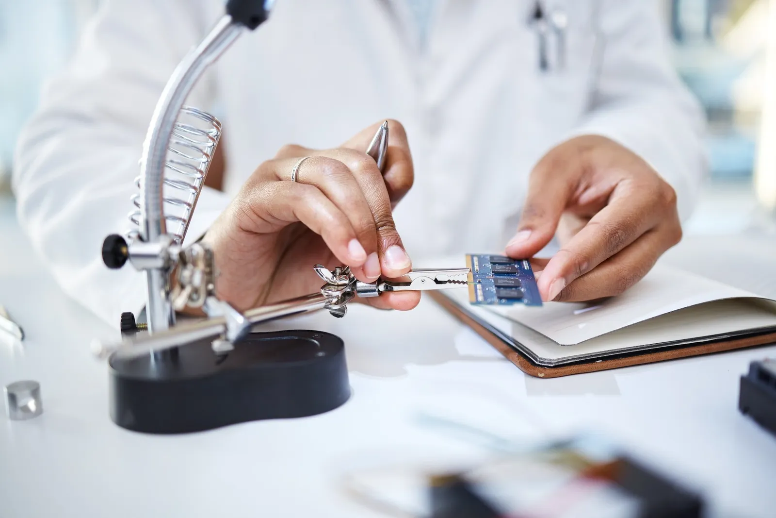 Hands, microchip and engineering woman with magnifying glass of science, maintenance and laboratory